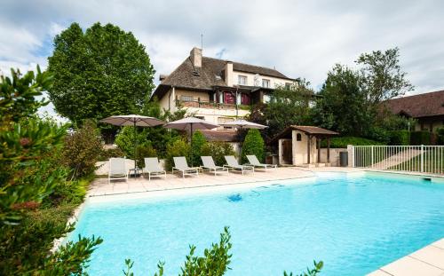 une piscine avec chaises et parasols devant une maison dans l'établissement Ermitage De Corton - Teritoria, à Chorey-lès-Beaune
