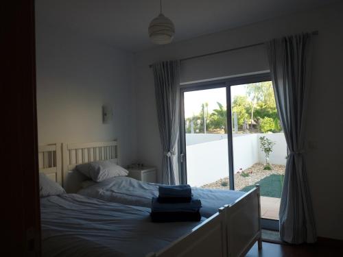 a bedroom with a bed and a large window at Rainha Juliana in Fuzeta