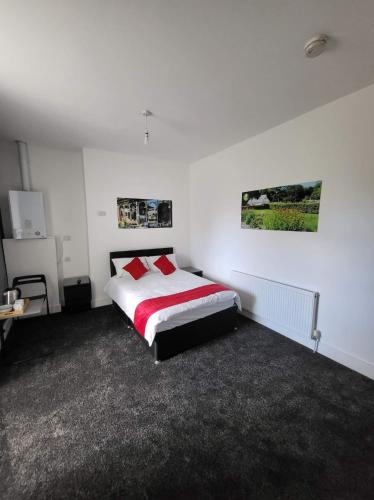 a bedroom with a bed with red pillows on it at Park View in Hull