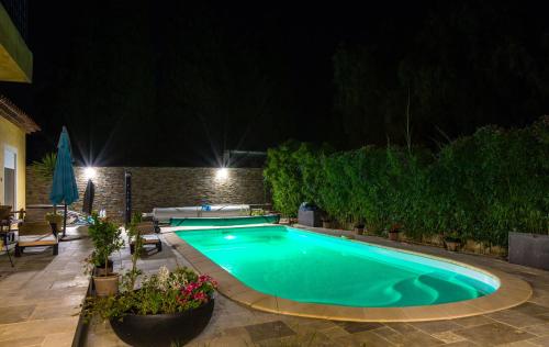 a swimming pool in a backyard at night at Chambres de la Terre Blanche in Sanary-sur-Mer