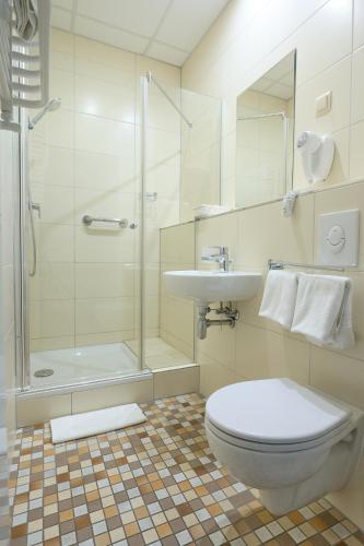 a bathroom with a toilet and a sink and a shower at Sky Business Hotel in Legnica