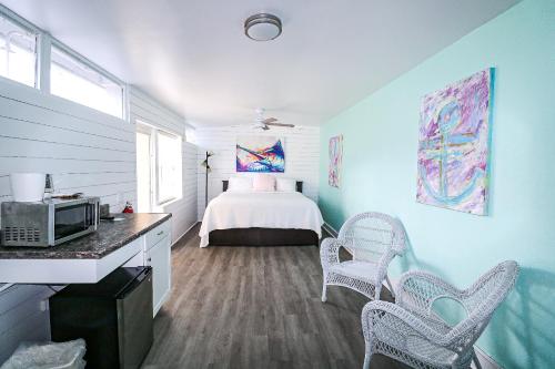 a bedroom with a bed and two chairs in it at Drop Anchor Resort & Marina in Islamorada