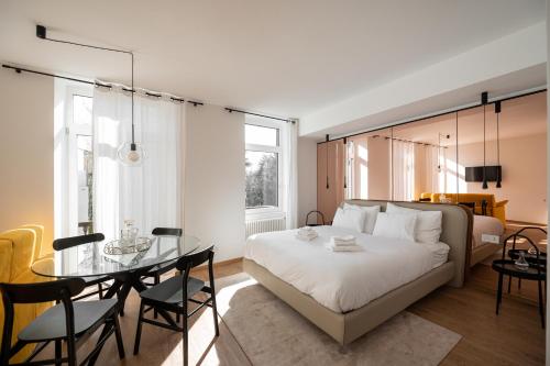 Guesthouse diWINE في ميرانو: غرفة نوم بسرير وطاولة وكراسي