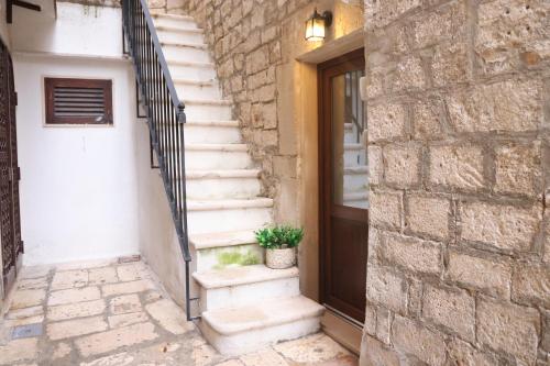 a set of stairs next to a door with a potted plant at Le Stanze di Maria-Ingresso Autonomo Maria's Rooms-Indipendent Entrance in Giovinazzo