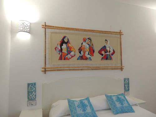 a painting on a wall above a white couch at Tenute Efis in Galtellì