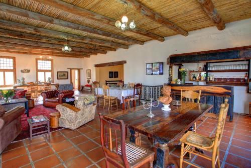 a living room with a wooden table and chairs at Keurfontein Country House in Willowmore