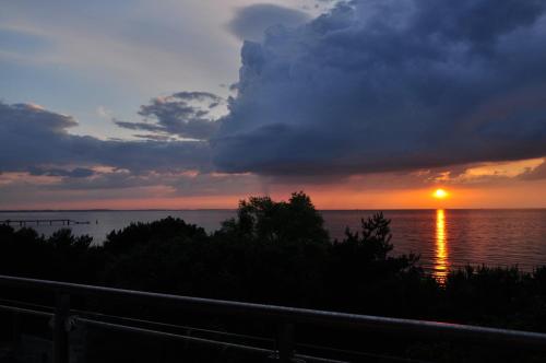 a sunset over the water with the sun setting at Promenada28pl - Apartamenty z widokiem na morze in Międzyzdroje