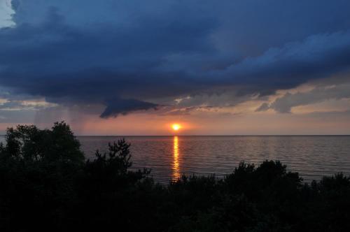 a sunset over the water with a cloudy sky at Promenada28pl - Apartamenty z widokiem na morze in Międzyzdroje
