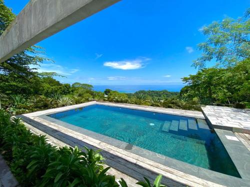 uma piscina numa villa com vista para o oceano em THEA Resort & Retreats - Santa Teresa em Santa Teresa