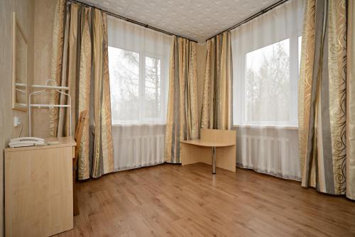 Habitación con cortinas, mesa y ventana en Hotel SRGK VOS, en Moscú