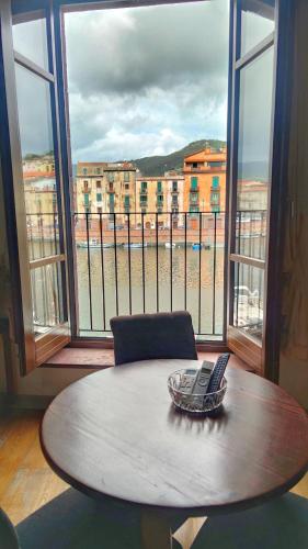 a table with a laptop on it in front of a window at Bosa Exclusive Apartments "Bosa Apartments" in Bosa