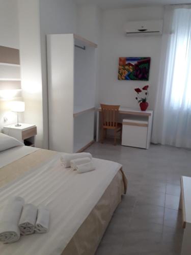 a bedroom with a bed and a desk and a table at Porto Cesareo Hotel in Porto Cesareo