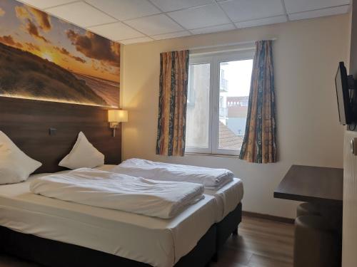 a bed in a hotel room with a window at Hotel Albert II Oostende in Ostend