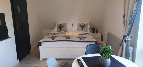 a small bedroom with a bed and a table at Apartament u krysi in Ząb