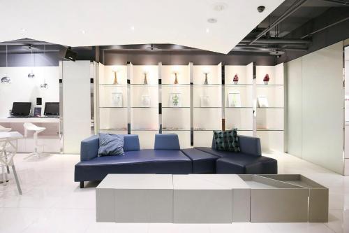 ein Wohnzimmer mit einem blauen Sofa und einem Tisch in der Unterkunft CityInn Hotel Plus - Ximending Branch in Taipeh