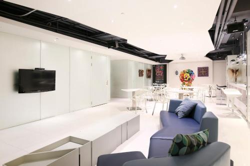 ein Wohnzimmer mit einem blauen Sofa und einem TV in der Unterkunft CityInn Hotel Plus - Ximending Branch in Taipeh