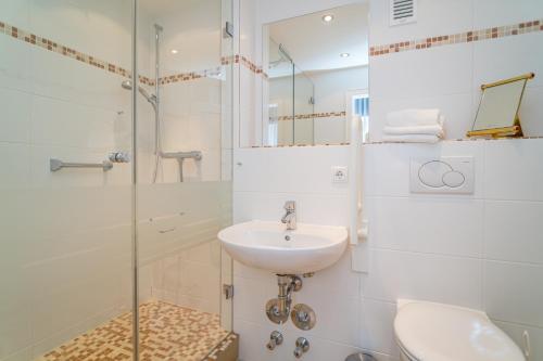 een badkamer met een wastafel en een glazen douche bij Haus Sola Bona Sola Bona 1 in Westerland