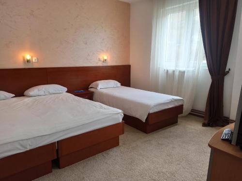 a hotel room with two beds and a window at Hotel Dominus in Bijelo Polje