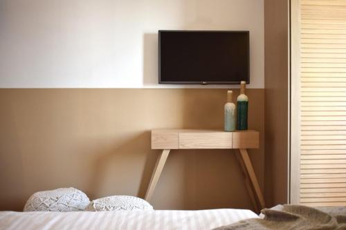 a bedroom with a tv on a stand with a bed at Meltemi in Skiathos Town