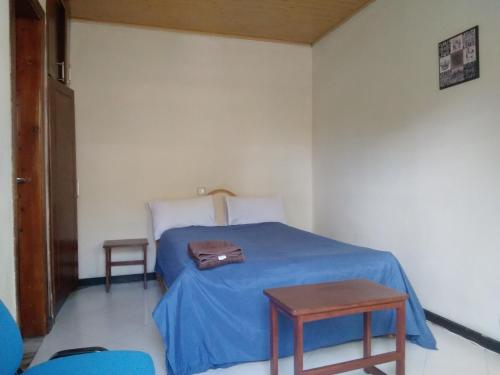 una camera con un letto blu e una borsa sopra di Wib Guesthouse ad Addis Abeba