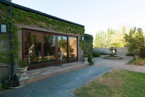 a house with windows and ivy on the side of it at Old House Lodge in Beaufort West