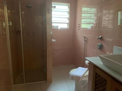 a bathroom with a shower and a toilet and a sink at Pousada Penedo in Penedo