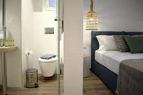 two images of a bedroom with a bed and a bathroom at Meltemi in Skiathos Town