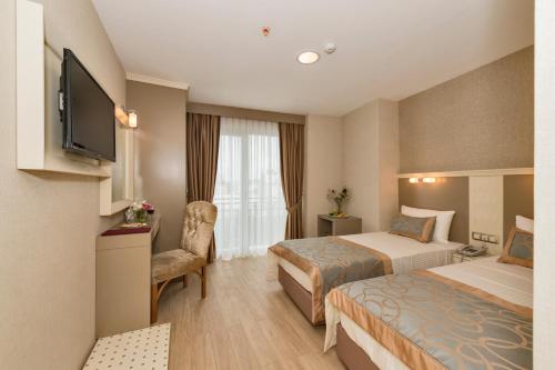 イスタンブールにあるMarcello Hotelのベッド2台とテレビが備わるホテルルームです。
