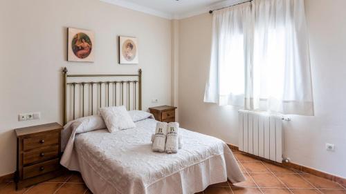 une chambre avec un lit avec deux chaussures dessus dans l'établissement Finca Cerro Alcolea Periana by Ruralidays, à Periana
