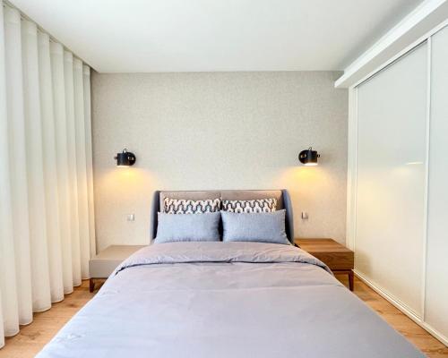 a bedroom with a bed with two blue pillows at Acta The Avenue in Porto