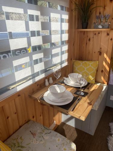 - une table avec des assiettes et des verres à vin dans l'établissement Shepherd's Hut at St Anne's - Costal Location, à Plymouth