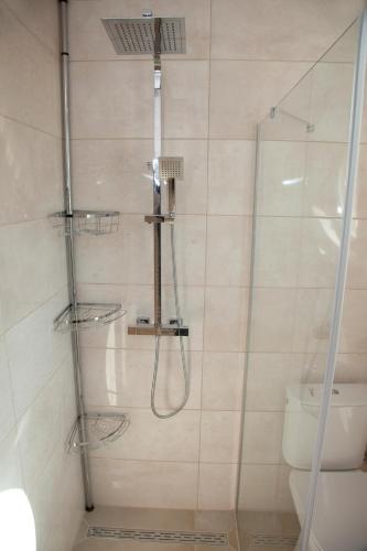 a shower with a glass door next to a toilet at Apartmán u Doktora in Banská Bystrica