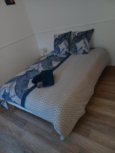 a bed with a comforter and pillows on it at Le quadrapin, studio 4 personnes centre ville Compiègne in Compiègne