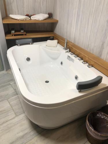 a large white bath tub in a bathroom at Valeni Boutique Hotel & Spa in Portariá