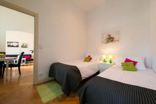 two beds in a room with a table and a mirror at Aston - Appartement Centre Ville Massena in Nice