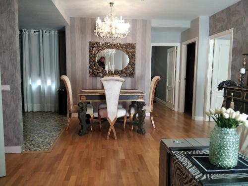 a dining room with a table with chairs and a mirror at VIP ROOMS Toledo - PARKING GRATIS - 2 HABITACIONES in Toledo