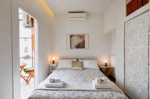 a white bedroom with a large bed with towels on it at Trevi Rome Central House in Rome