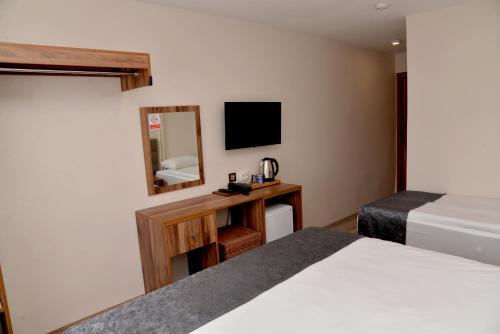um quarto de hotel com uma cama e um espelho em Zümrüt Palas Otel em Erciyes