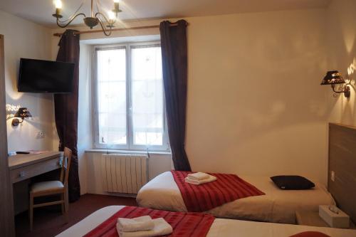 a hotel room with two beds and a window at HOTEL DES VOYAGEURS in Pont-de-Roide