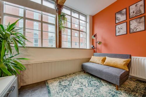 a living room with orange walls and a couch at Lovely Central 1 Bed Apartment Sleeps 4 in Sheffield