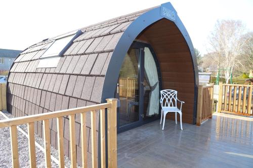 a small building with a chair on a deck at The Kellbank in Gosforth