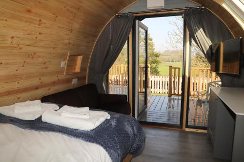 a bedroom with a bed and a balcony with a television at The Kellbank in Gosforth