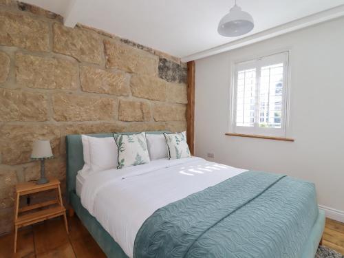 uma cama num quarto com uma parede de tijolos em Penistone View em Keighley