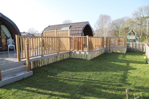 a wooden fence in a yard with a house at The Kellbank in Gosforth