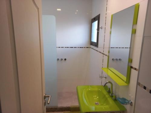 baño con lavabo verde y espejo en DEPARTAMENTOS MORENO en San Rafael
