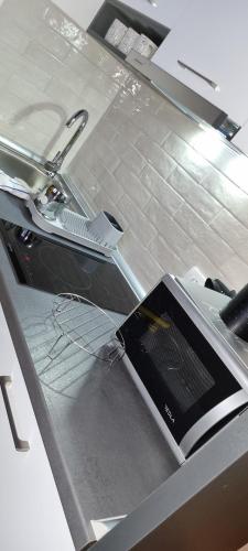 a kitchen counter with a sink with a laptop on it at Kraljevi Cardaci 9D 12- Sunny view in Kopaonik