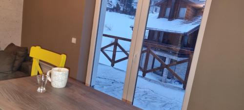 a sliding glass door with a view of a cabin at Kraljevi Cardaci 9D 12- Sunny view in Kopaonik