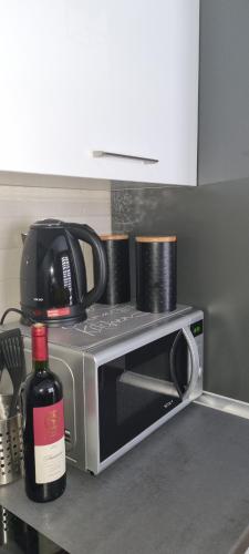 a microwave on a kitchen counter with a bottle of wine at Kraljevi Cardaci 9D 12- Sunny view in Kopaonik