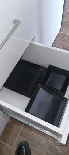 a drawer in a white counter top with a blackinsula at Kraljevi Cardaci 9D 12- Sunny view in Kopaonik