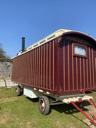 um vagão de comboio em exposição na relva em Vintage Showman's Wagon For Two Close to Beach em Plymouth